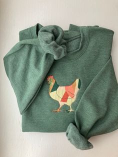 Your favorite cozy chicken sweater made of a patchwork style fabric. Please note that each sweater is unique based on how the fabric is stitched. Patchwork Cotton Sweater For Spring, Cute Patchwork Tops For Fall, Green Cotton Patchwork Sweater, Fall Cotton Patchwork Sweater, Cute Green Cotton Sweater, Cozy Patchwork Crew Neck Tops, Multicolor Cotton Sweatshirt For Fall, Cozy Cotton Sweater With Patchwork, Long Sleeve Sweatshirt With Patches For Fall