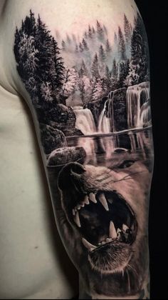 a man's arm with a bear and waterfall tattoo on the upper half of his arm