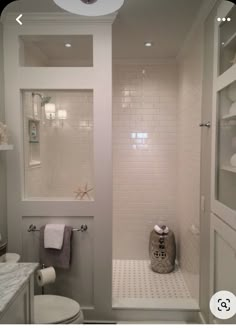 a bathroom with white tile walls and floor