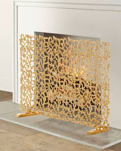 a gold fireplace screen sitting on top of a hard wood floor