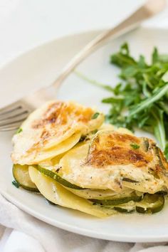 a white plate topped with green vegetables and an omelet on top of it