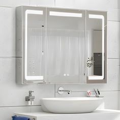 a white sink sitting under a bathroom mirror