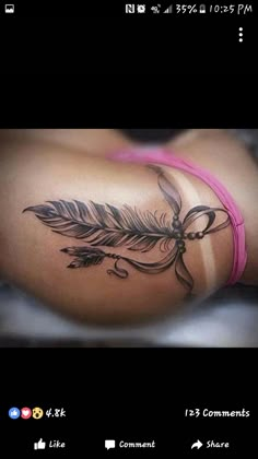 a woman's stomach with a feather tattoo on the side of her body and an arrow