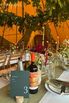 the table is set with wine bottles and place cards for guests to eat in front of them