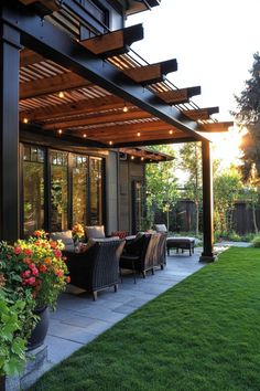 Modern outdoor patio with wicker chairs and string lights under a wooden pergola, surrounded by lush greenery. Backyard Patio With Roof, Patio Attached To House Covered, Open Covered Porch Ideas, Exterior Shades Patio, Covered Deck Addition, Adding A Covered Back Patio, Carport Makeover Outdoor Spaces, Covered Patio With Retractable Screens, Covered Porch Addition