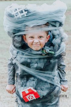 a young boy wearing a costume made out of plastic