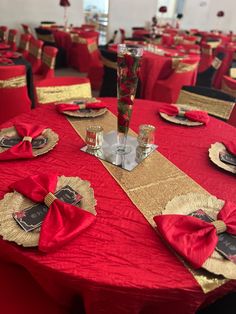 red and gold table cloths with place settings on them are ready for an event