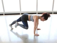 a woman is doing push ups on the floor