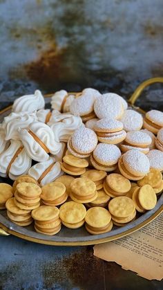 a plate full of cookies and pastries on top of a table with an open book