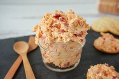 a glass jar filled with food next to crackers