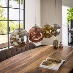 a wooden table topped with three hanging lights