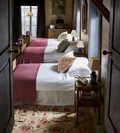 there are two beds in the room with red and white blankets on them, one is next to another bed