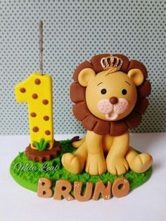 a cake shaped like a lion sitting on top of a green grass covered field next to a number one