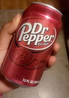 a person holding a can of dr pepper