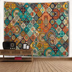 a wall hanging on the side of a wooden floor in front of a large tapestry