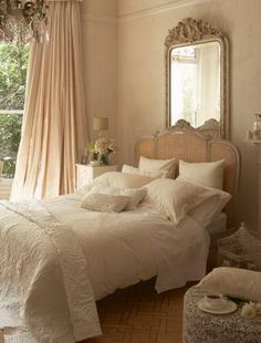 a white bed sitting in a bedroom next to a window