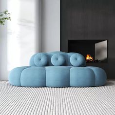 a blue couch sitting on top of a white floor next to a fire place in a living room