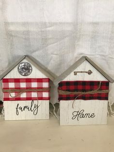 two small wooden houses with the words family and home painted on them, sitting side by side