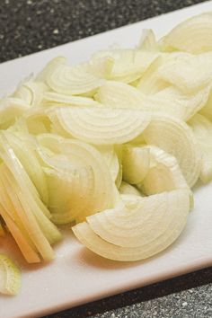 sliced onions are on a cutting board next to a knife