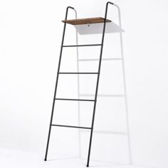 a ladder leaning against a white wall with a wooden shelf on the top and bottom