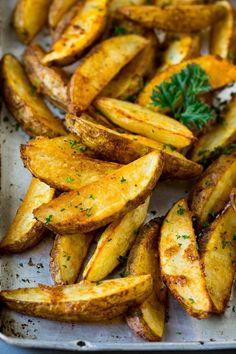 baked potato wedges with parsley on top in a baking pan, ready to be eaten