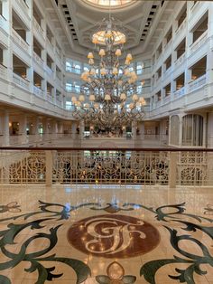 a chandelier hanging from the ceiling in a large room with marble flooring