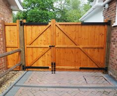 a wooden gate in front of a brick building