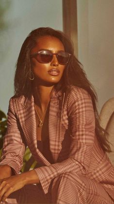 a woman sitting on top of a couch wearing sunglasses