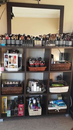 a large mirror sitting above a shelf filled with different types of cosmetics and other items