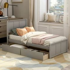 a bed with two drawers underneath it in a room next to a dresser and window