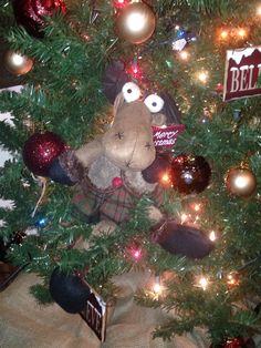 a stuffed animal sitting in the middle of a christmas tree