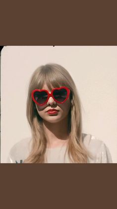 a woman with long blonde hair wearing red heart shaped sunglasses