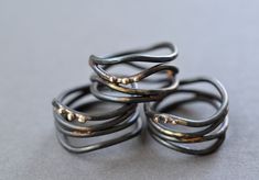 Organic wrap rings, reminiscent of vines,  are fabricated from forged steel wire that has been brazed together with brass and accented with small beads of recycled 10k gold.  Available in whole and half sizes, 4-11.  Rings are around 12mm across at their widest point.  Note Because of the width of the rings its recommended to order a half size larger than you normally would. Due to the handmade nature of these rings, each one is unique and exact design will vary from the photo. Steel has been se Wrap Around Ring, Interlocking Circle Necklace, Interlocking Ring, Gold Circle Necklace, Blackened Steel, Small Beads, Wide Ring, Ring Hand, Wrap Ring