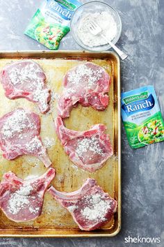 raw pork chops on a baking sheet with powdered sugar and seasonings next to them