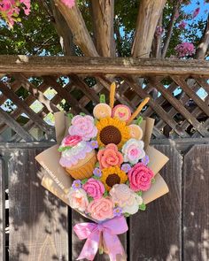 a bouquet of flowers sitting on top of a wooden fence