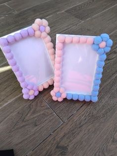 two frames with pom - poms are sitting on the floor