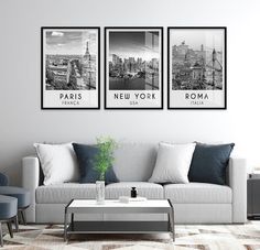 three black and white pictures hang on the wall above a couch in a living room