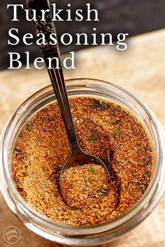 a jar filled with seasoning sitting on top of a wooden table