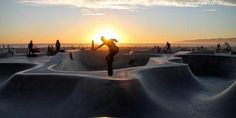 a skateboarder is doing tricks at the top of a ramp in front of the sun