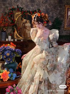 a woman is sitting on a chair in a room with flowers and vases behind her