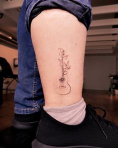 a person with a guitar tattoo on their leg