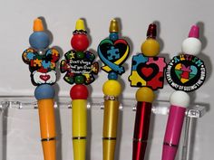 several different colored pens are lined up in a holder with magnets on them,