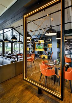 the interior of a restaurant with chairs and tables in front of a large mirror that is reflecting an outdoor area