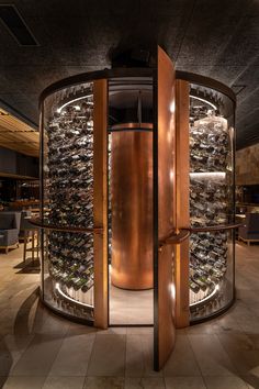 a wine cellar with lots of bottles in it's glass walls and doors open