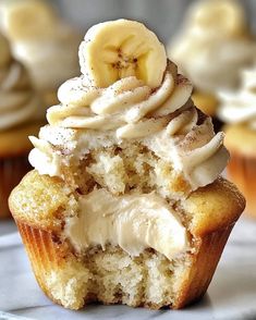 a cupcake with white frosting and a banana cut in half