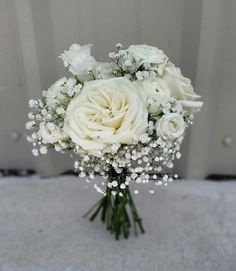 a bouquet of white roses and baby's breath