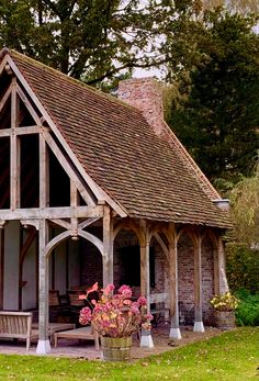 an old wooden building with flowers in the front