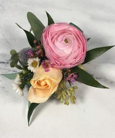 a bouquet of flowers sitting on top of a white countertop next to a marble wall