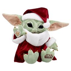 a star wars baby yoda plush toy wearing a santa hat and holding a paw