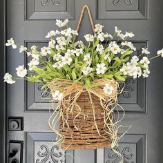 a basket with flowers hanging from the front door